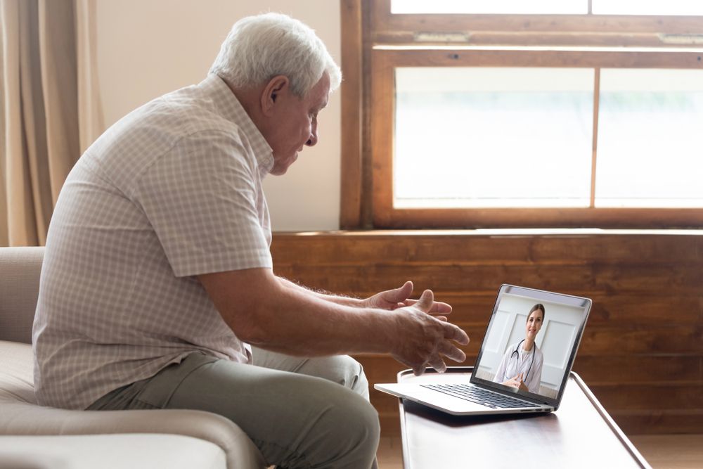Elderly man using telehealth to consult with a doctor